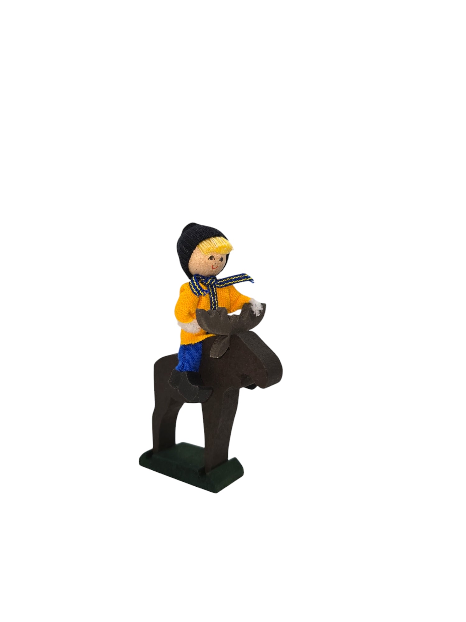 A hand-crafted figurine features a Swedish boy in winter clothing riding on a wooden moose.