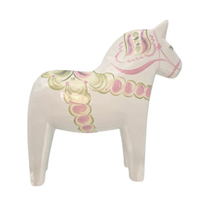 A hand-carved Dala Horse: Pastel on White Swedish Dala Horse with Kurbits, exquisitely hand-painted in white, pink, and green with decorative patterns, viewed from the side.