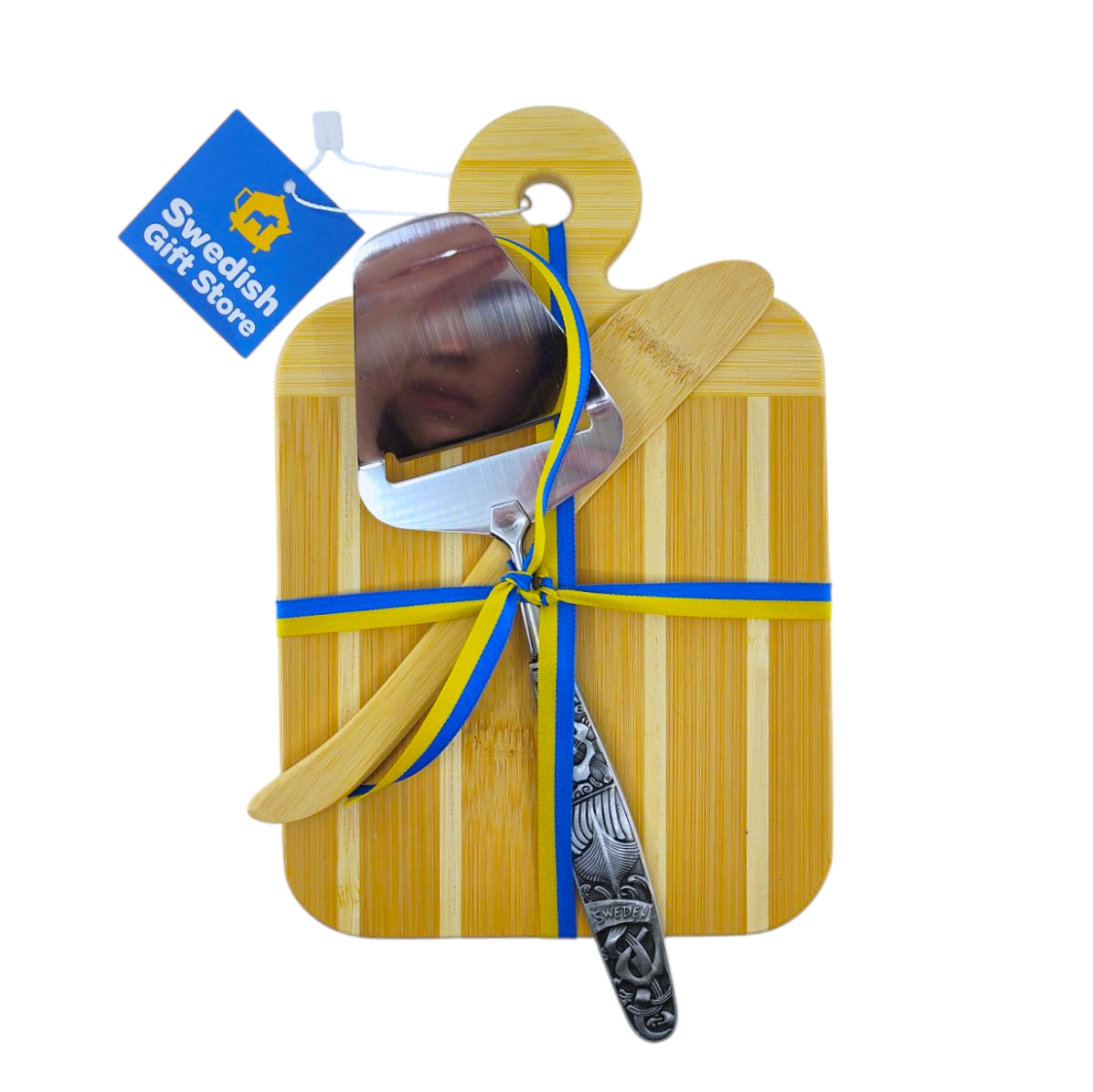 This Swedish Gift Store set features a bamboo cutting board with a cheese slicer, spreader, and decorative knife, elegantly tied together with a blue and yellow ribbon. Its an ideal gift for any occasion.