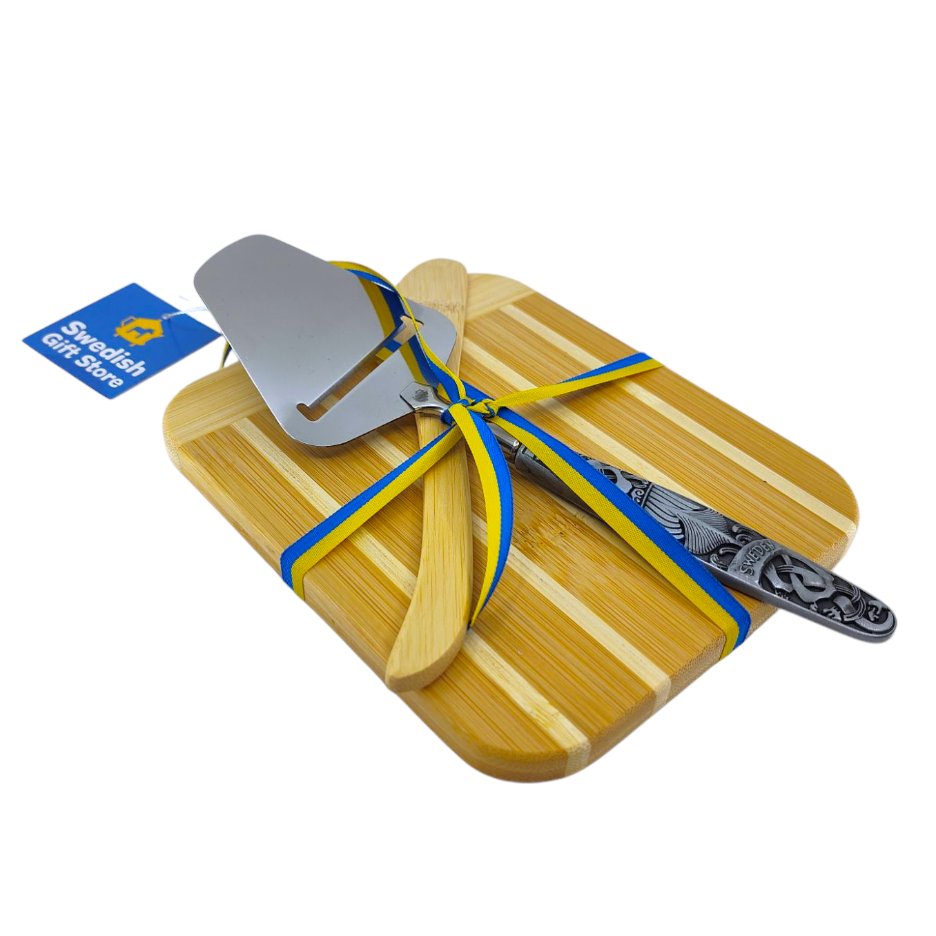 The Swedish Cheese Slicer & Bamboo Cutting/Serving Board set, featuring an ornate handle and decorated with a blue and yellow ribbon, comes from a Swedish gift store. Perfect for serving at any occasion.