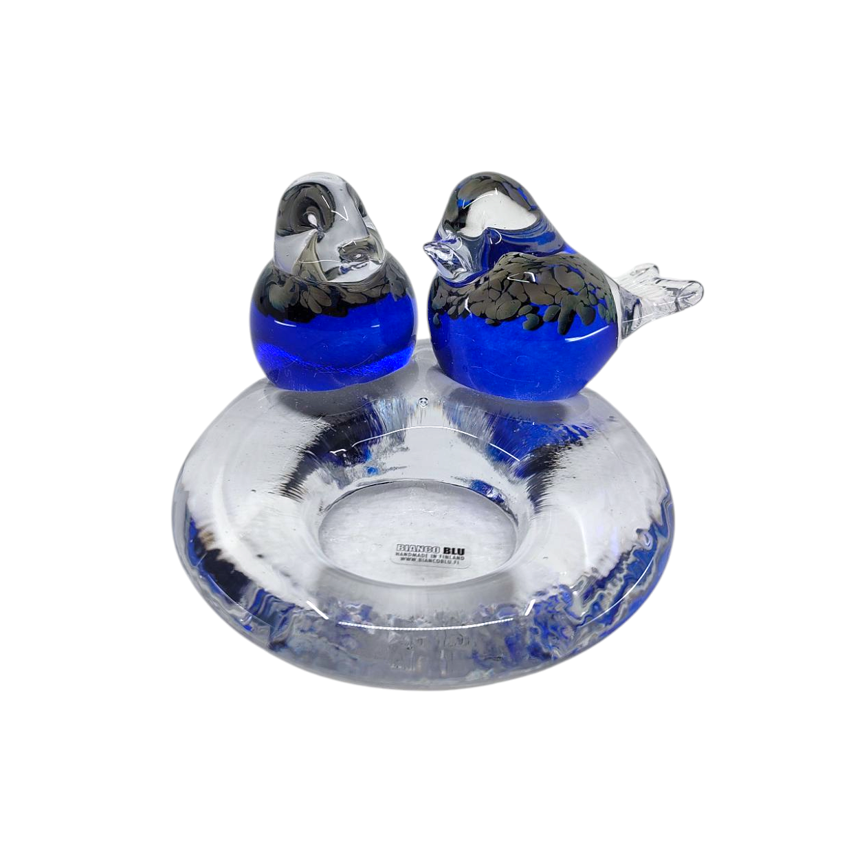 The Candle Holder: Glass Candle Holder w/ 2 Blue Birds features two glass bird figurines with blue accents elegantly perched on a clear, ring-shaped glass base, creating a unique and decorative display.