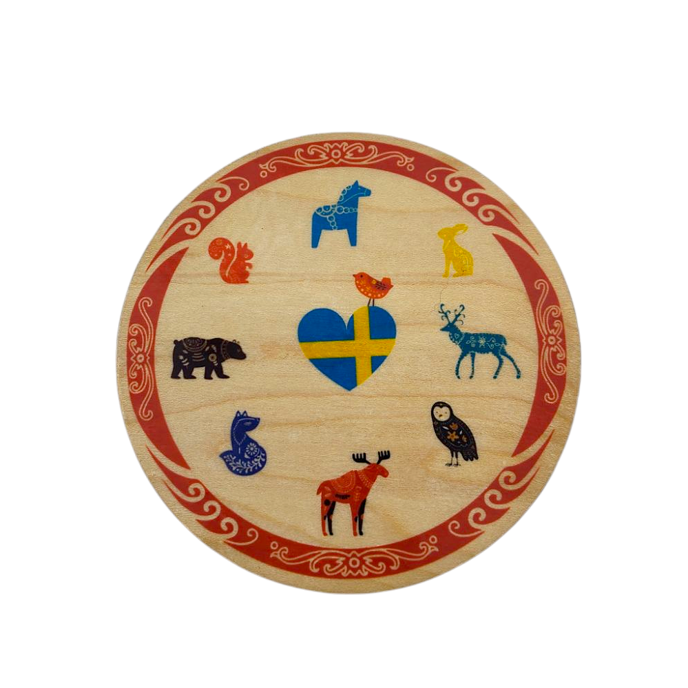 The Birch Swedish Animals Coaster from a Swedish Gift Store is a charming round wooden plaque, adorned with a heart-shaped Swedish flag and vibrant illustrations of animals like a moose, owl, and fox, bordered with red patterns.