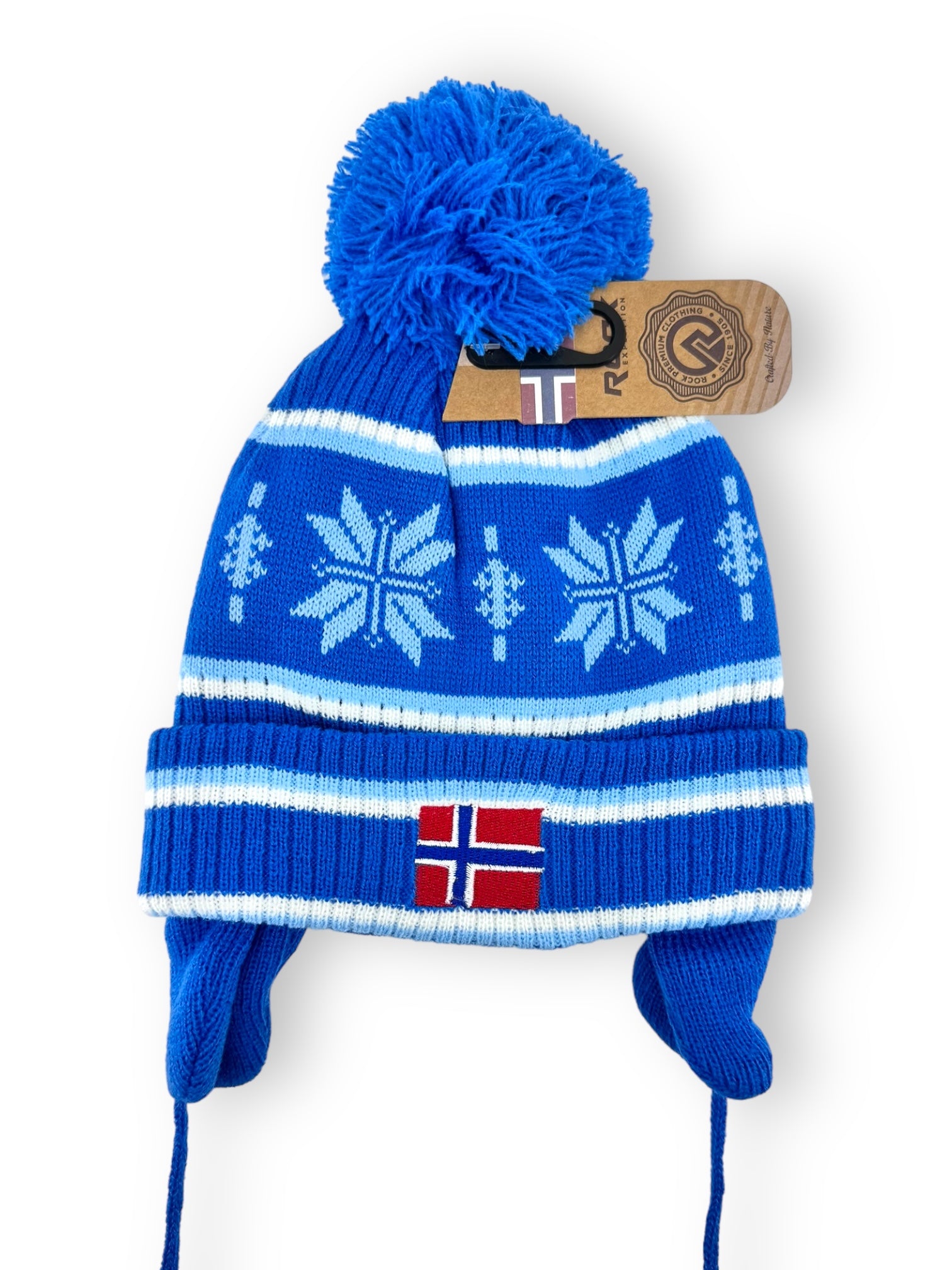 Rock Expedition child's acrylic hat in blue, featuring snowflake patterns, ear flaps, a pompom, and an Icelandic flag on the front. Comes with a cardboard tag attached.