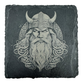 Engraved image of a Viking warrior with horned helmet and beard on a square slate coaster. The design, from the Coaster: Warrior, Viking Head - Celtic Viking Symbol Slate Coaster, is inspired by Norse mythology and Celtic Viking symbols.