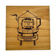 A 4x4 square alder coaster features the Lindstrom Coffee Pot Water Tower with Swedish text and floral design, plus a platform labeled Lindström Minnesota—a charming tribute to Scandinavian FIKA tradition.