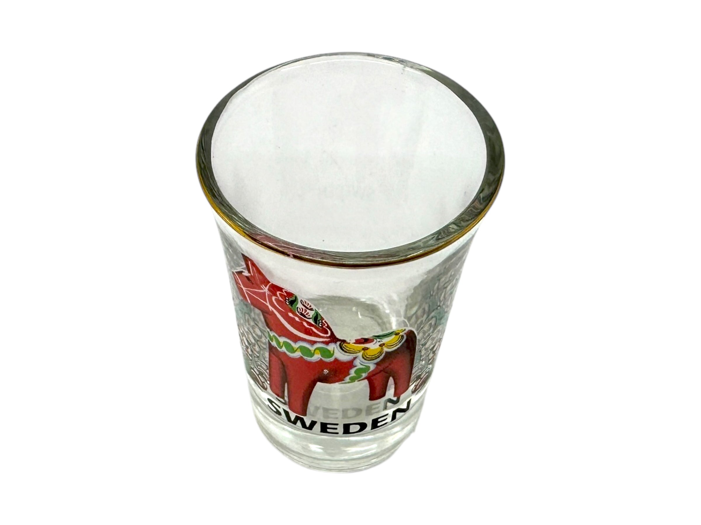 The Shot Glass: Sweden Red Dala Horse displays a Sweden Red Dala Horse and the word Sweden, inspired by Scandinavian folk art, shown on clear glass against a white background.