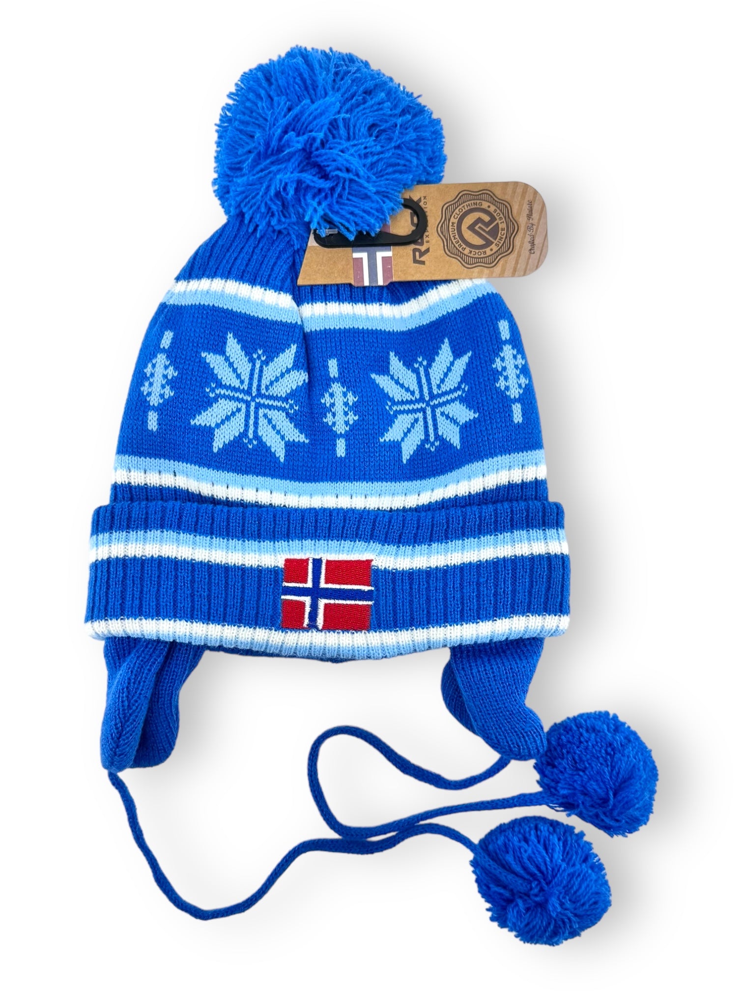 Blue Rock Expedition child's acrylic hat featuring snowflake patterns, a pom-pom on top, ear flaps with tassels, a small Norwegian flag, and a brown tag.