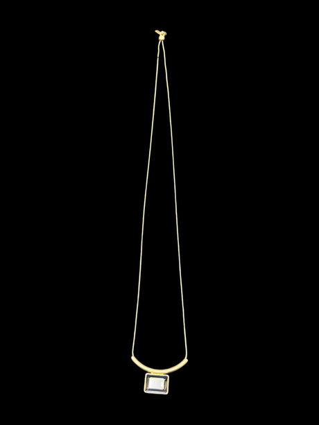 The Audrey Black Diamond Gold Plated Necklace by DANSK Copenhagen features a thin gold chain with a central rectangular pendant, all set against a black background, epitomizing minimalist jewelry.