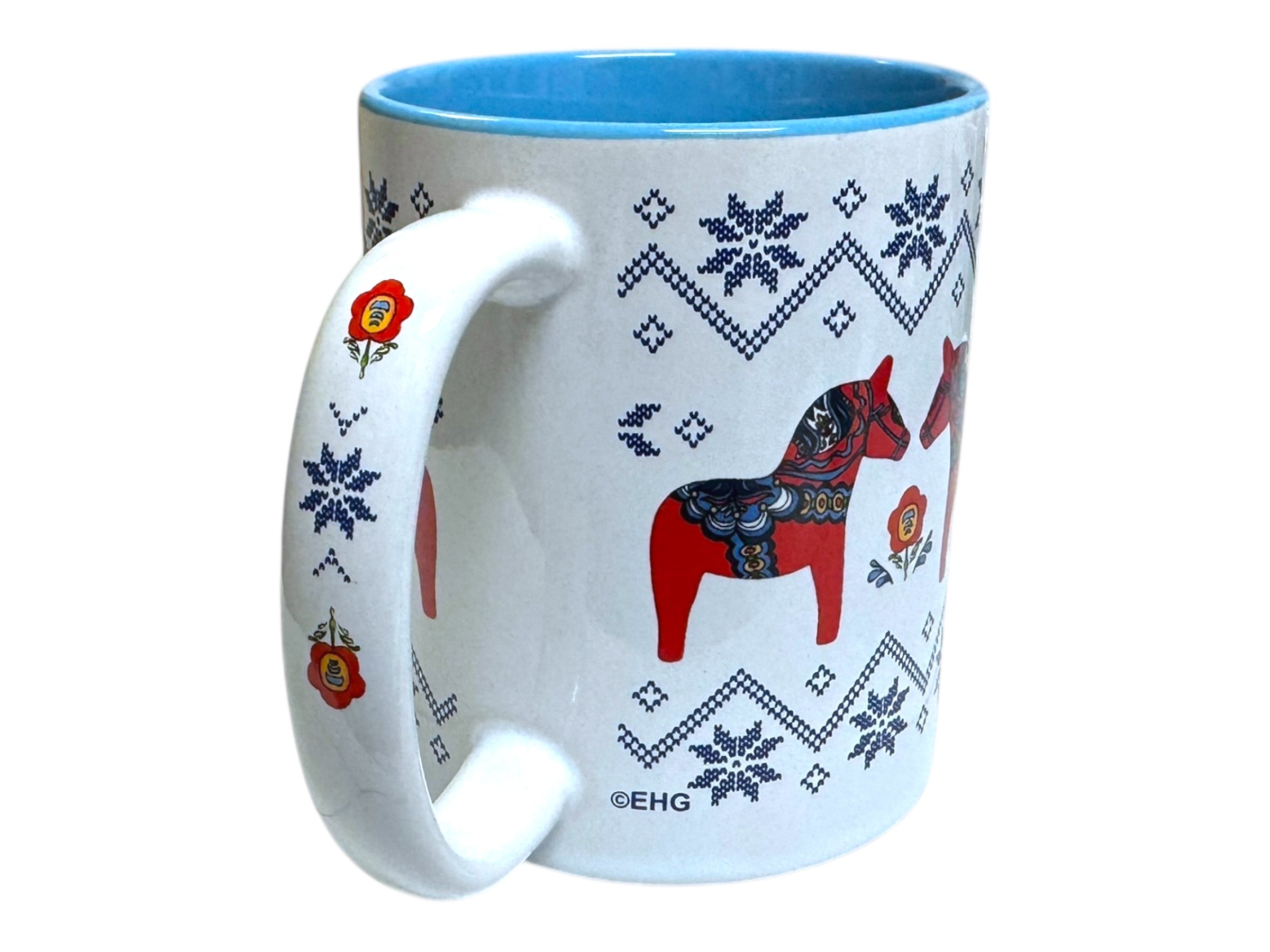 The Mug: Dala Horse Snowflake Design Ceramic Coffee Cup - Blue Interior features a white exterior, charming blue interior, and is adorned with red Swedish Dala Horses, blue snowflakes, and a floral motif on the handle.