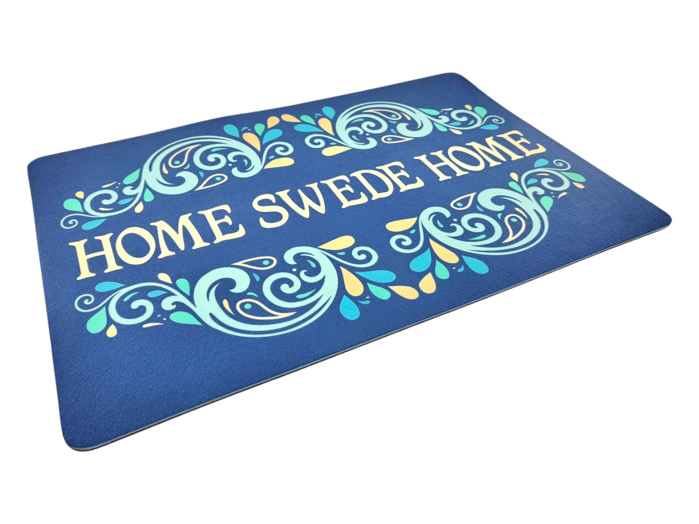 The Rug: Home Swede Home 16 x 24 is a blue novelty rug with a decorative swirl pattern and yellow HOME SWEDE HOME text, perfect for adding Scandinavian charm to any room.