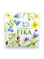 Illustration of flowers, strawberries, a ladybug, and a cup with Garden Fika text on a Swedish dish cloth background designed by Marie Stendahl.