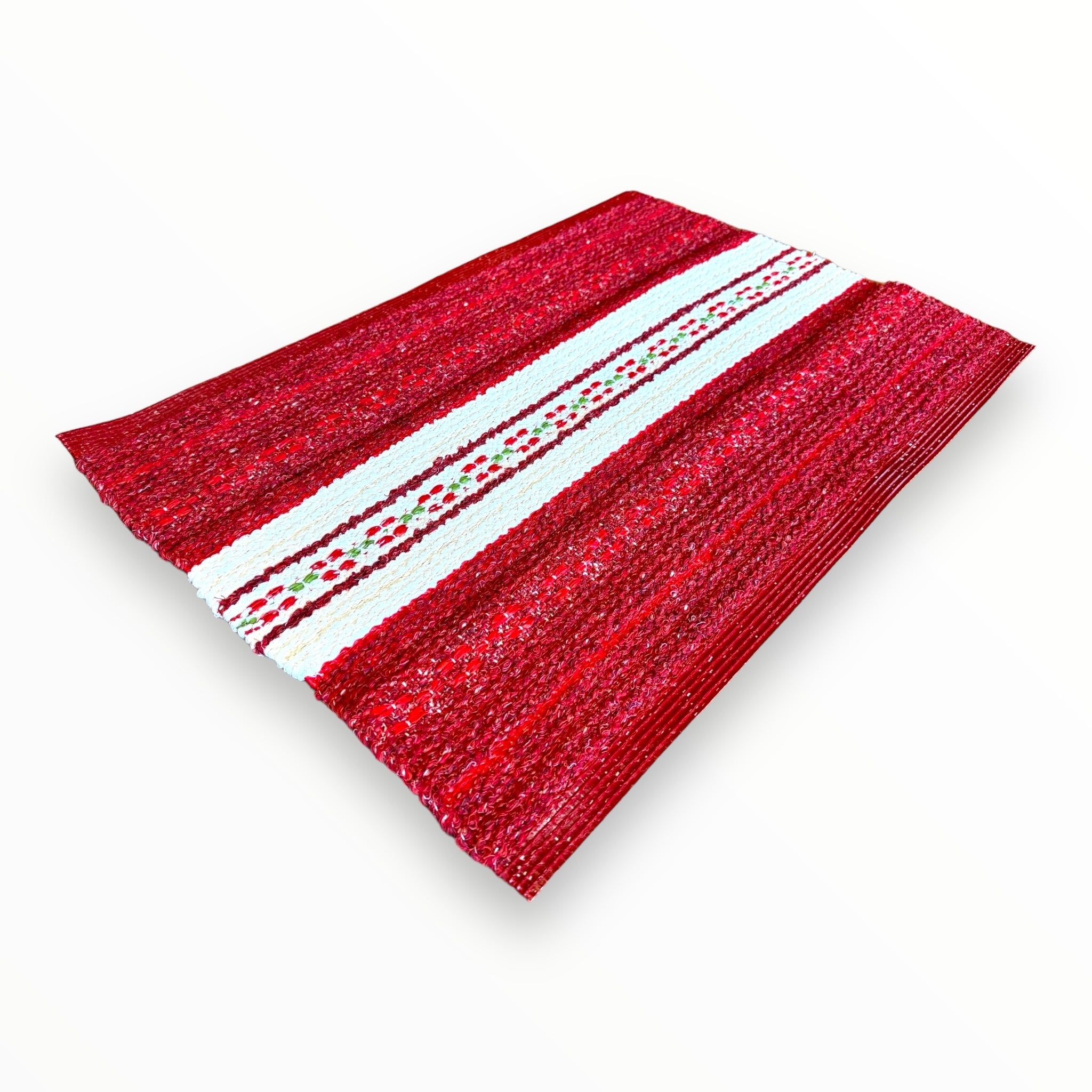 The Rug: Mixed Asta - Red, crafted from cotton and vinyl, showcases a durable, heavy-duty design with a rectangular red pattern and a striking white patterned central stripe against a white background. This Swedish vinyl woven rug is ideal for enhancing both indoor and outdoor spaces with its stylish functionality.