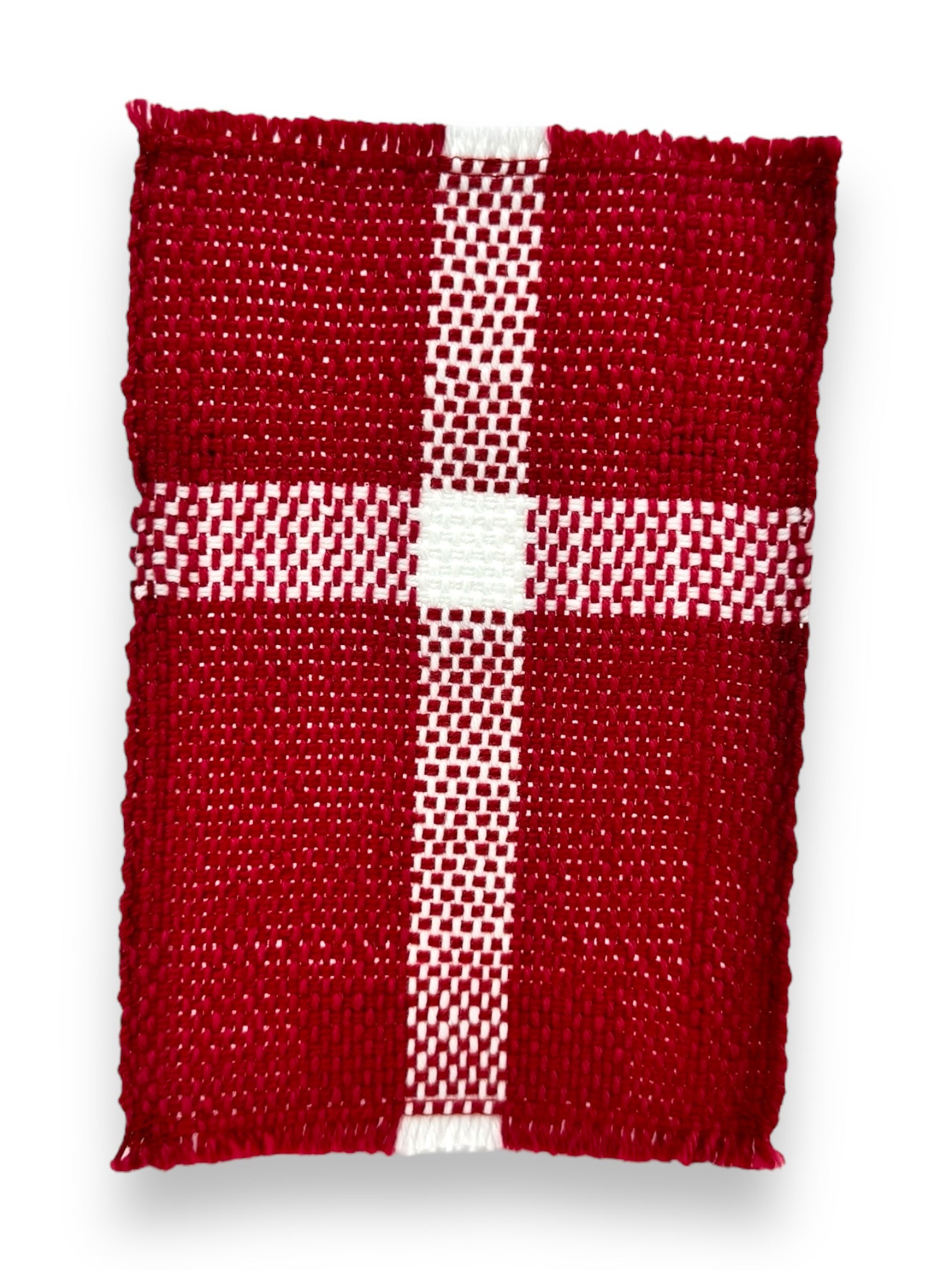 This rectangular coaster, named "Denmark Flag," measures 6.5"x4" and features a hand-woven checkerboard pattern with intersecting stripes on a white background, reminiscent of the Danish flag. Made from 100% cotton, it combines both style and functionality.