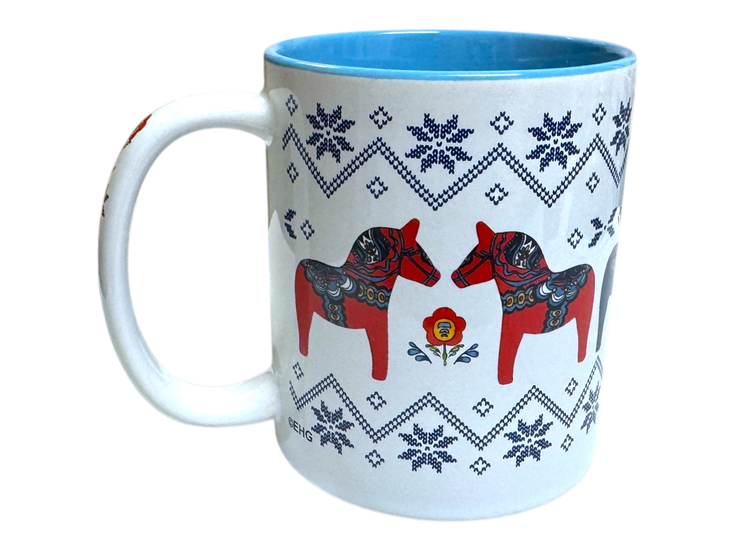 Explore the charm of the Mug: Swedish Dala Horses with Ice Star Design, featuring a blue interior and depicting Dala horses amidst floral patterns and snowflake motifs, embodying Scandinavian design.