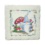 A blue-hatted gnome sits by red mushrooms and flowers, framed by a floral border on a textured square—ideal for the Coaster: Spring Tomte - Gnomes Tumbled Tile Coaster Set of 4 Square 4" with absorbent stone and cork backing.