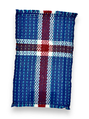 The coaster, named "Coaster: Iceland Flag (6.5"x4")," is intricately handwoven with a pattern that mirrors the blue, red, and white cross of the Icelandic flag.