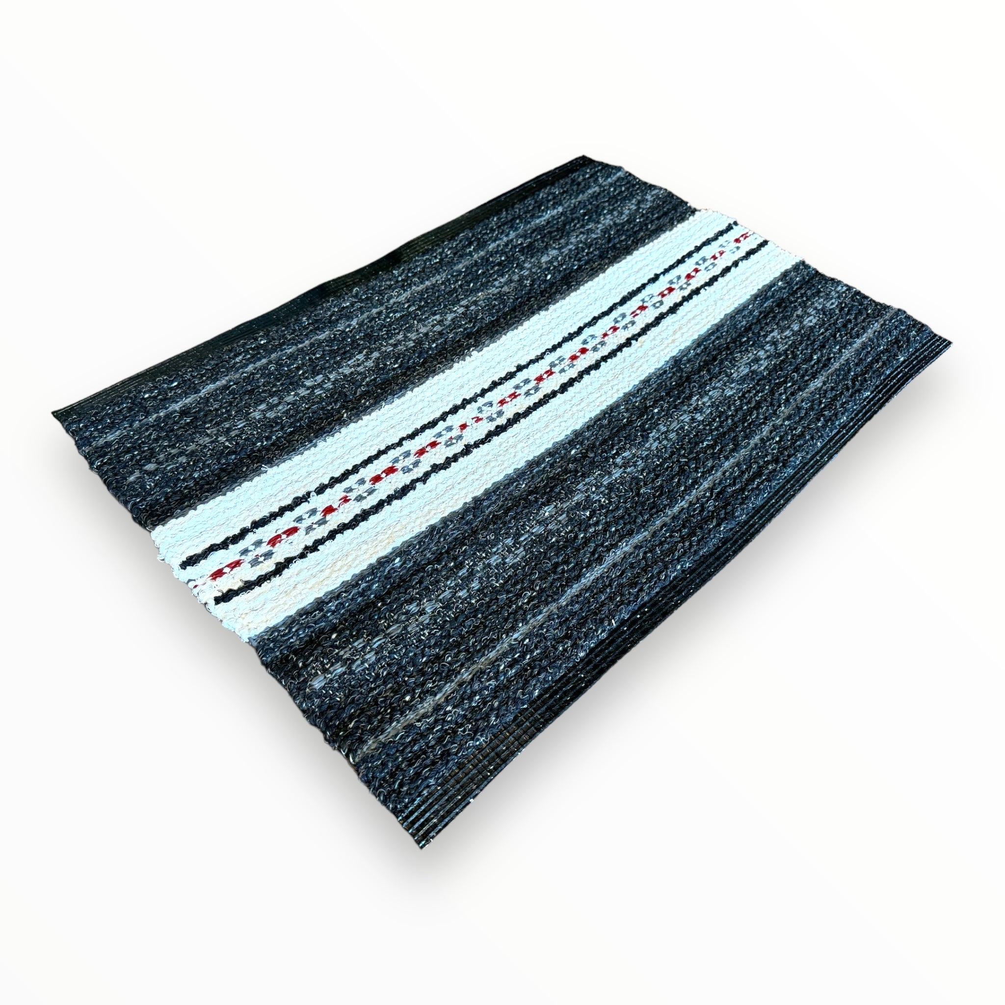 A woven blanket in black and white with a central stripe featuring small red and black patterns, reminiscent of the Mixed Asta - Black Swedish rug made from cotton and vinyl.