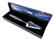 A jagged Norwegian cheese slicer & cutter with a pewter handle featuring a Viking ship and moose image, presented in a box—a tribute to Scandinavian heritage.