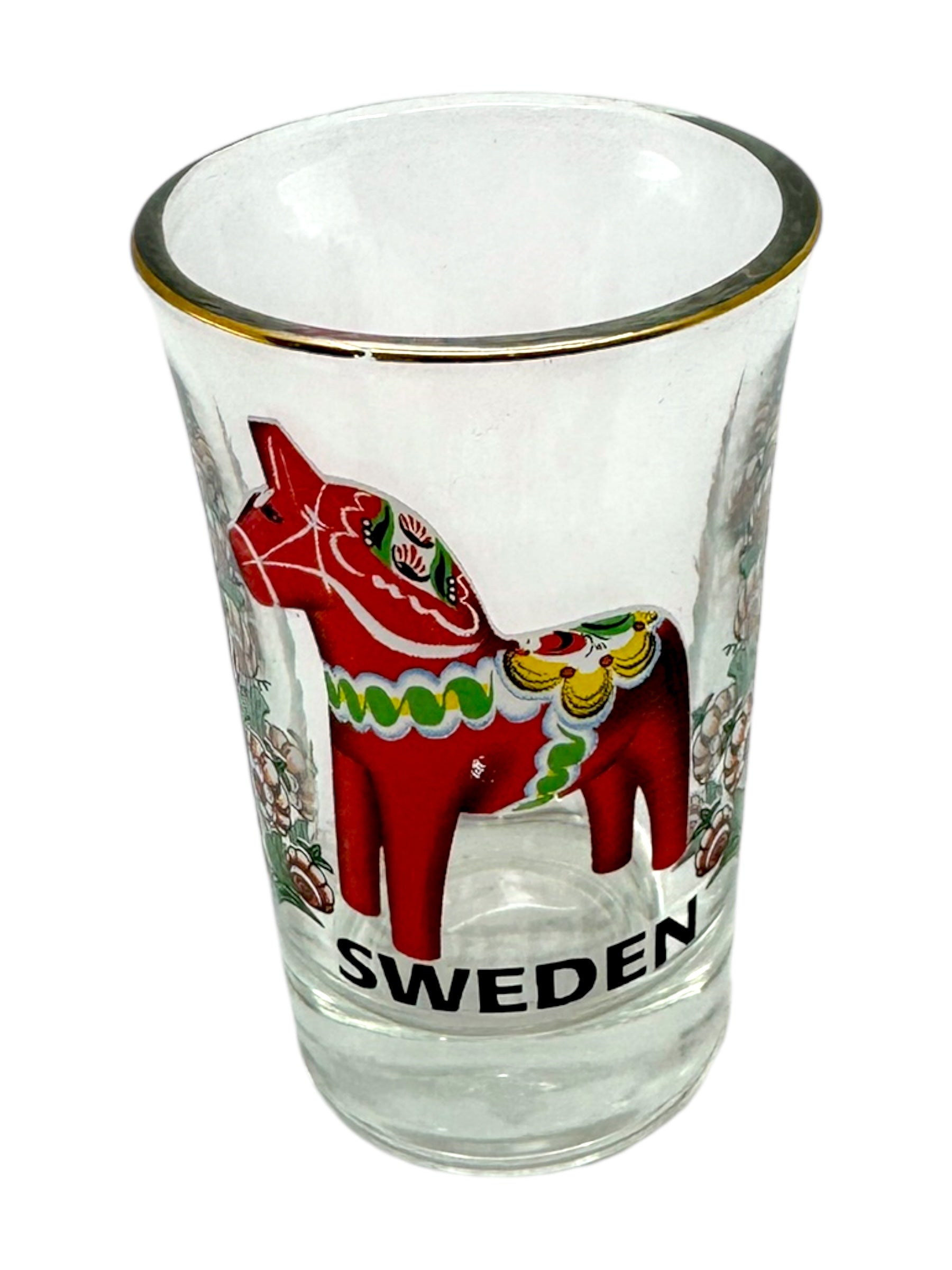 The Shot Glass: Sweden Red Dala Horse features a Scandinavian folk art-inspired red Dala horse, Sweden lettering, and a gold rim—a charming Nordic souvenir.