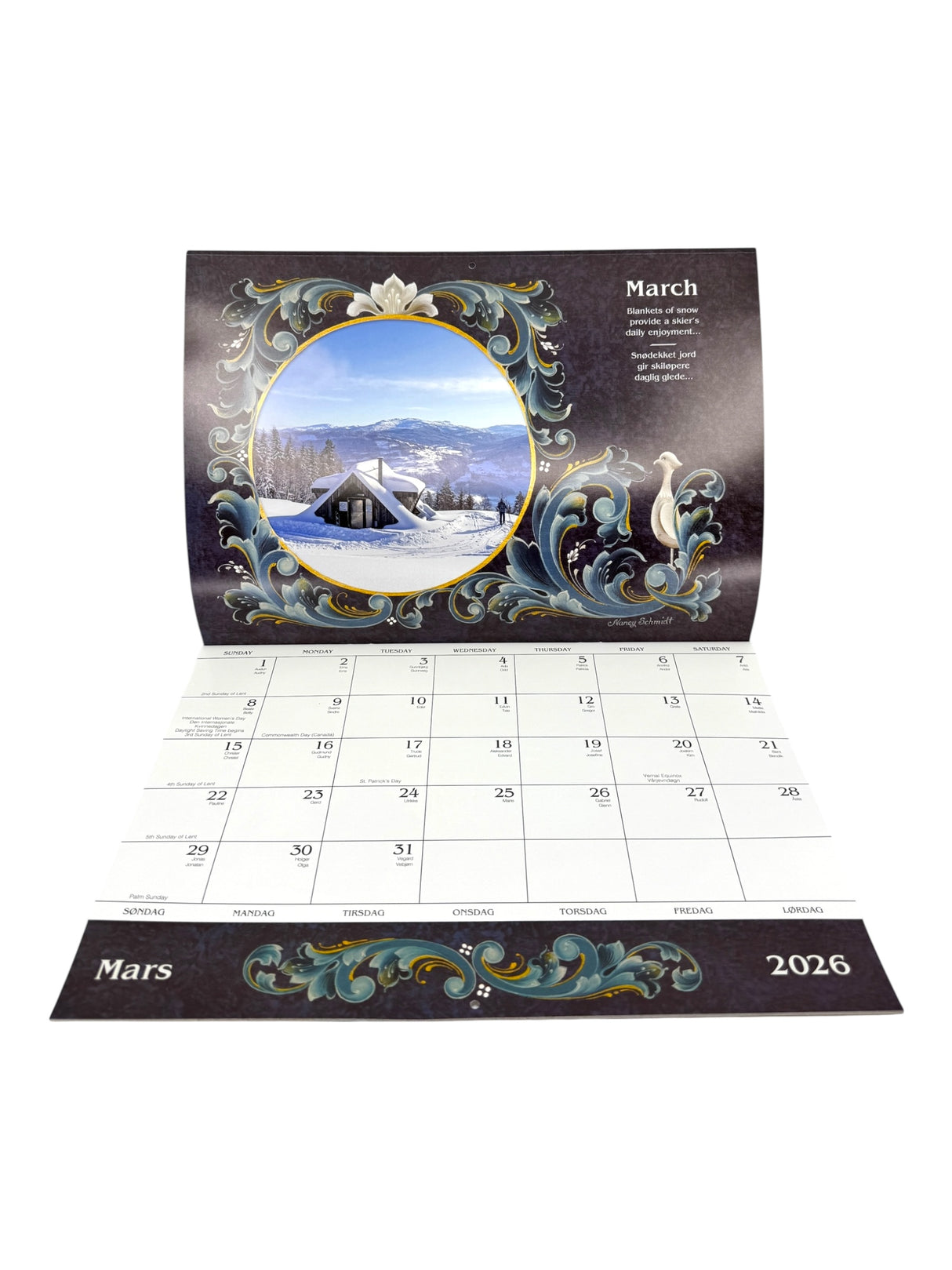 The Calendar: Norway 2026 Wall Calendar – Visions & Verse of Vikingland displays March 2026 with a decorative border and a winter scene of snow-covered mountains and a cozy Norwegian house.