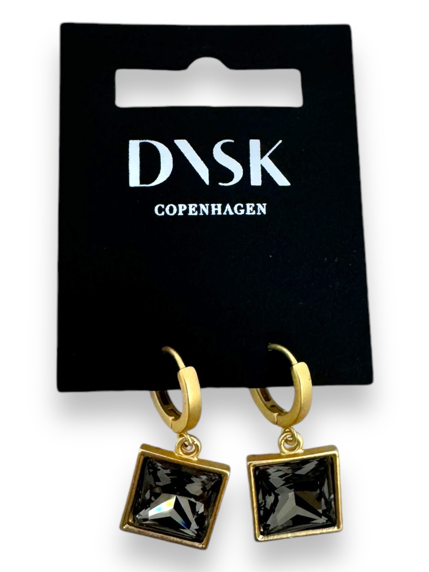 Audrey Black Diamond Gold Plated earrings, featuring a minimalist Nordic design with square black crystals set in gold hoops, elegantly presented on DNVK Copenhagen branded packaging.