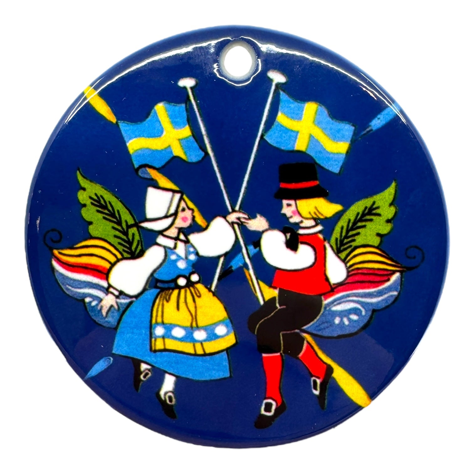Ornament: Swedish Dancers—porcelain ornament showing dancers in traditional Swedish attire with flags and decorative leaves, celebrating Scandinavian culture.