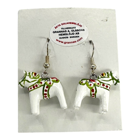 A pair of Dala Horse White Earrings – Handcrafted Swedish Folk Art (2cm/0.75 high) featuring red and green details, displayed on a Grannas A. Olssons Hemslöjd AB, Nusnäs Sweden card—a delightful touch of Swedish tradition.