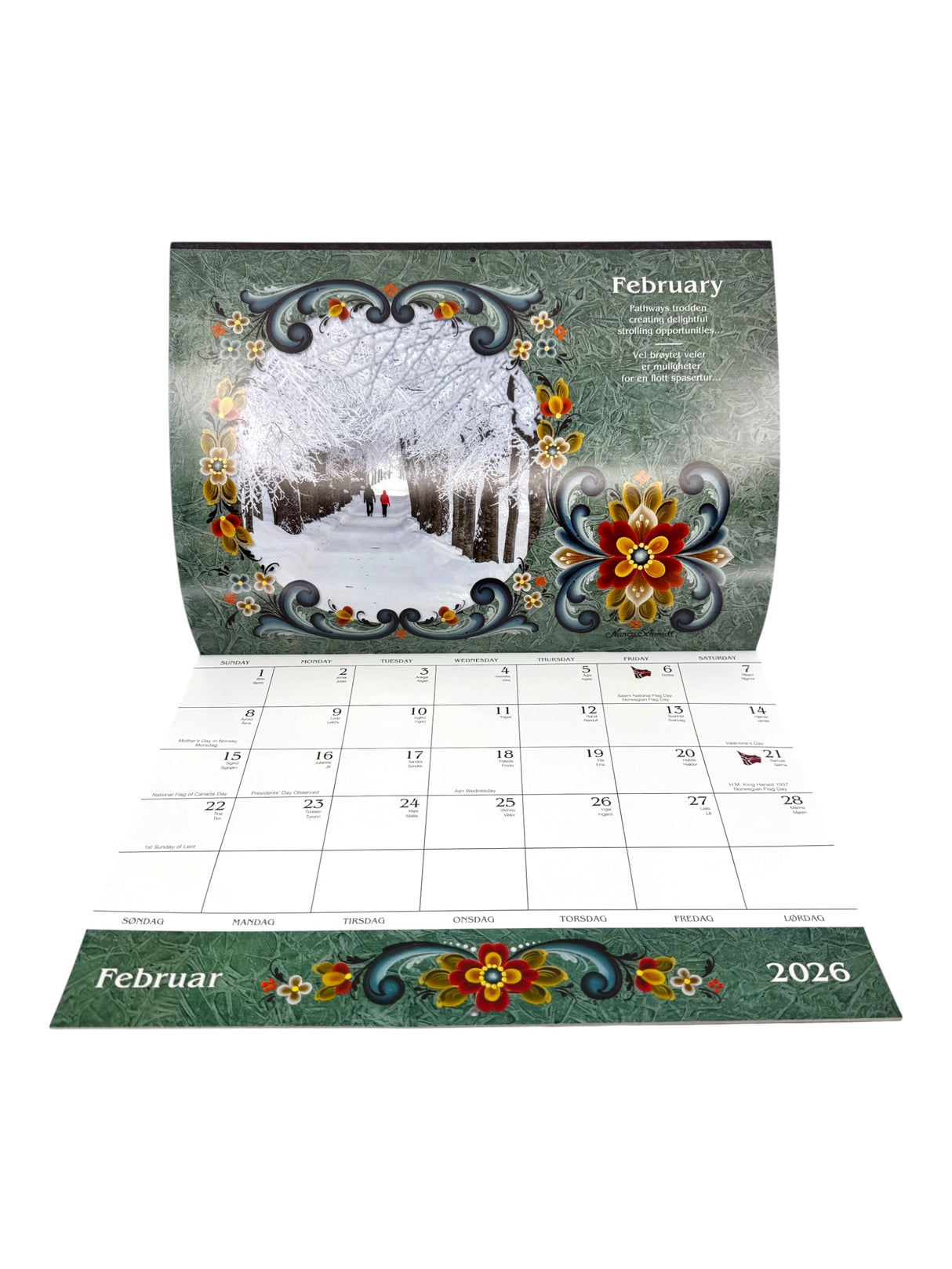 The Calendar: Norway 2026 Wall Calendar – Visions & Verse of Vikingland displays February 2026 with floral motifs and a winter scene inspired by Norwegian culture, featuring people strolling in a snowy park.