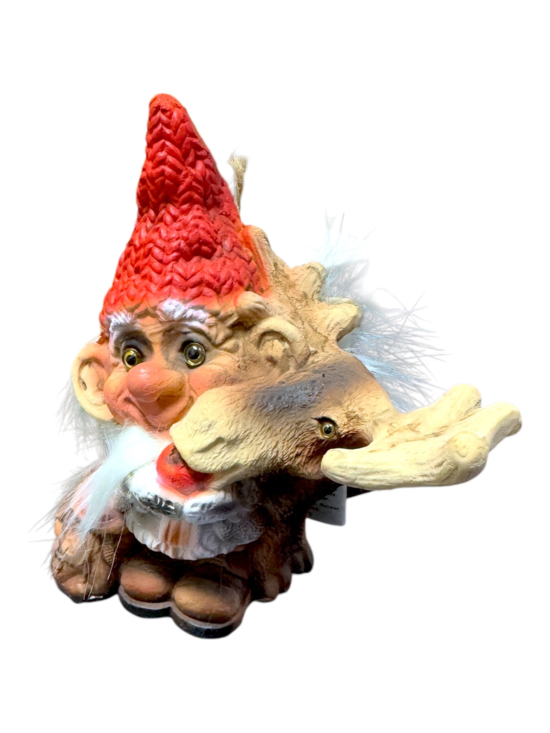 The "Troll: NyForm - Nissen Feeding Moose" figurine captures the whimsy and charm of Norwegian Design, featuring a gnome with a red hat and white beard embracing a moose with large antlers, echoing the enchanting characteristics of NyForm Trolls.