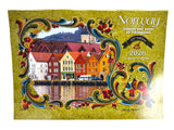 The front cover of the Calendar: Norway 2026 Wall Calendar – Visions & Verse of Vikingland features colorful traditional waterside buildings, an ornate floral border, and text celebrating Norwegian culture through vivid images and verse.