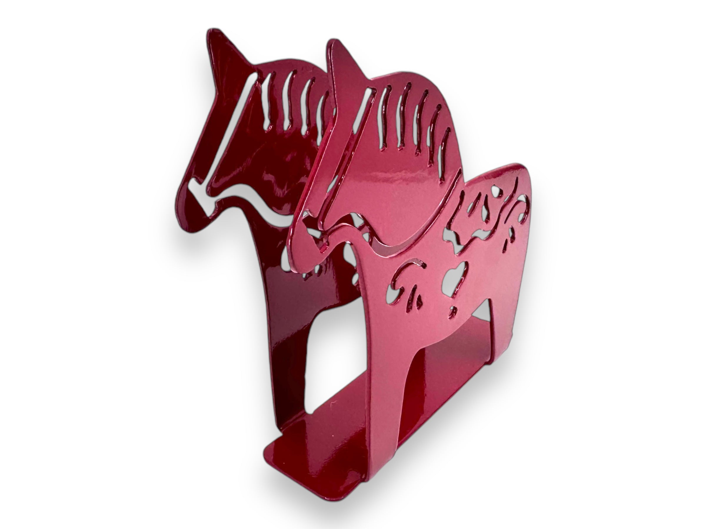 The Napkin Holder: Laser Cut Metal Dala Horse is a red metal piece shaped like two horses, featuring intricate laser-cut kurbits designs that add a touch of elegance to any table setting.