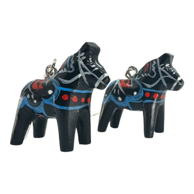Two black Dala Horse earrings (2cm/0.75 high) inspired by handcrafted Swedish folk art, featuring blue, red, and white painted patterns and a metal loop—perfect for adding a touch of tradition to your jewelry collection.