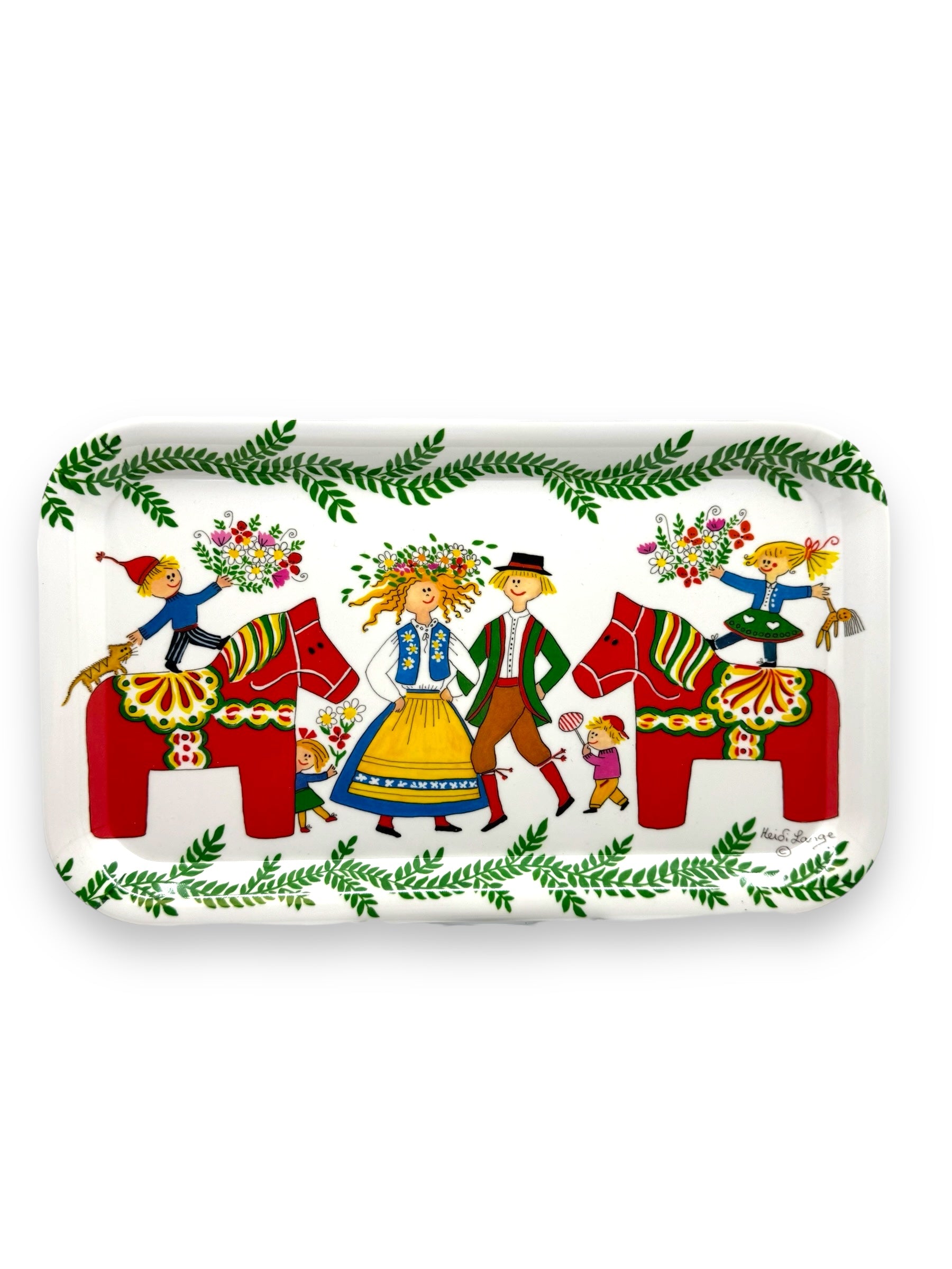 This vibrant art tray, the "Tray: Dala Horses, Swedish Motifs," showcases people in traditional Swedish attire along with Dala horses and floral patterns, all encircled by leafy borders. It beautifully captures the classic charm of a Heidi Lange design.