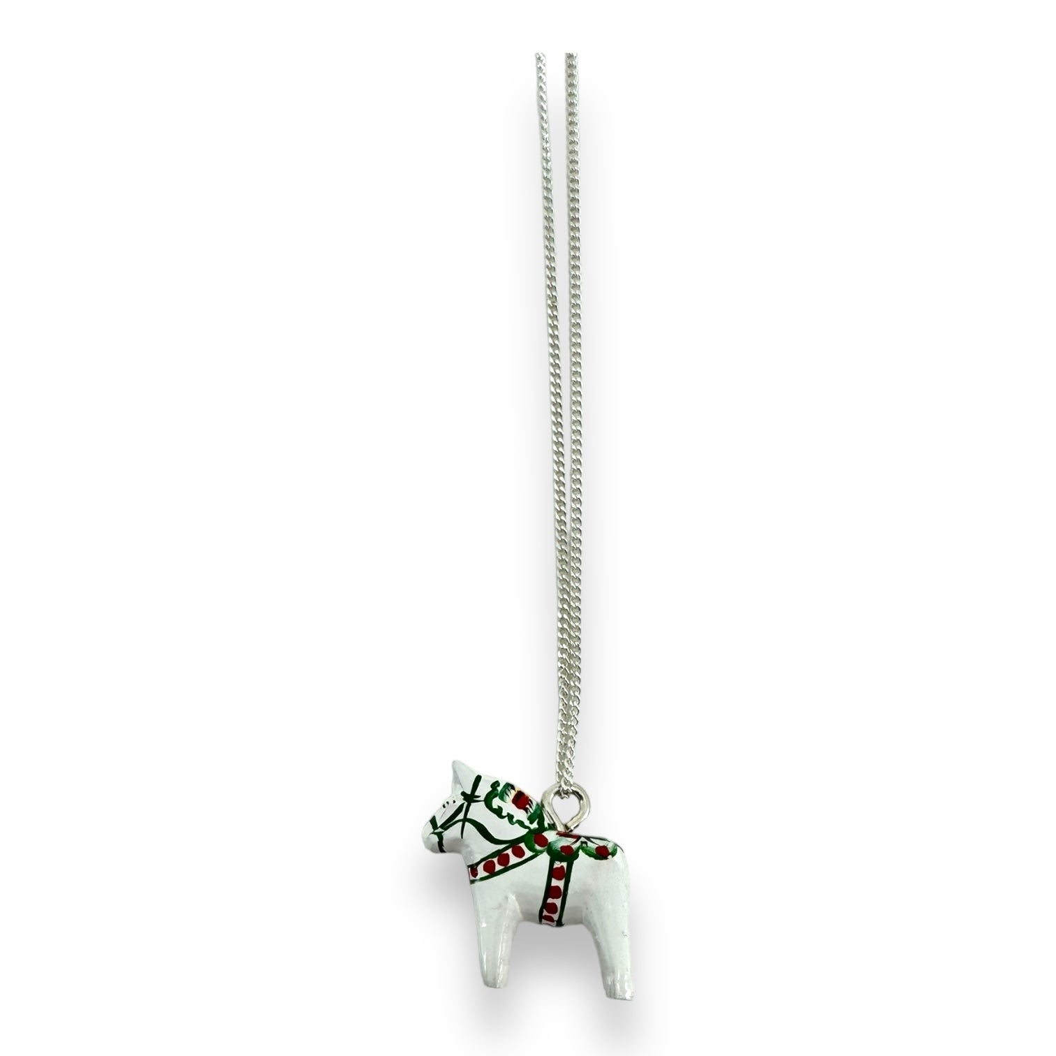 This necklace, named "Dala Horse Necklace White 3cm," showcases a hand-crafted pendant in the shape of a white Swedish Dala Horse, adorned with striking red and green accents, elegantly suspended from a silver chain.