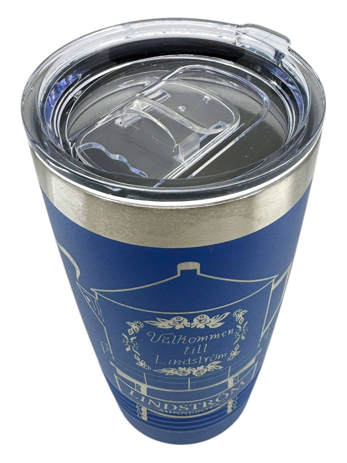 The 20oz Polar Camel tumbler features a blue stainless steel body, white line art of the Lindström Coffee Pot Water Tower, Välkommen till Lindström text, and a clear slide-shut lid—perfect for daily travel.