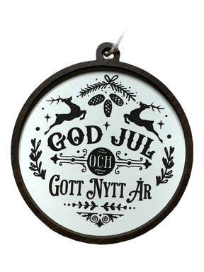 God Jul White & Gott Nytt År ornament features black holiday text with reindeer, pinecones, and foliage on white; hangs by a string—a festive way to celebrate Swedish Christmas traditions.