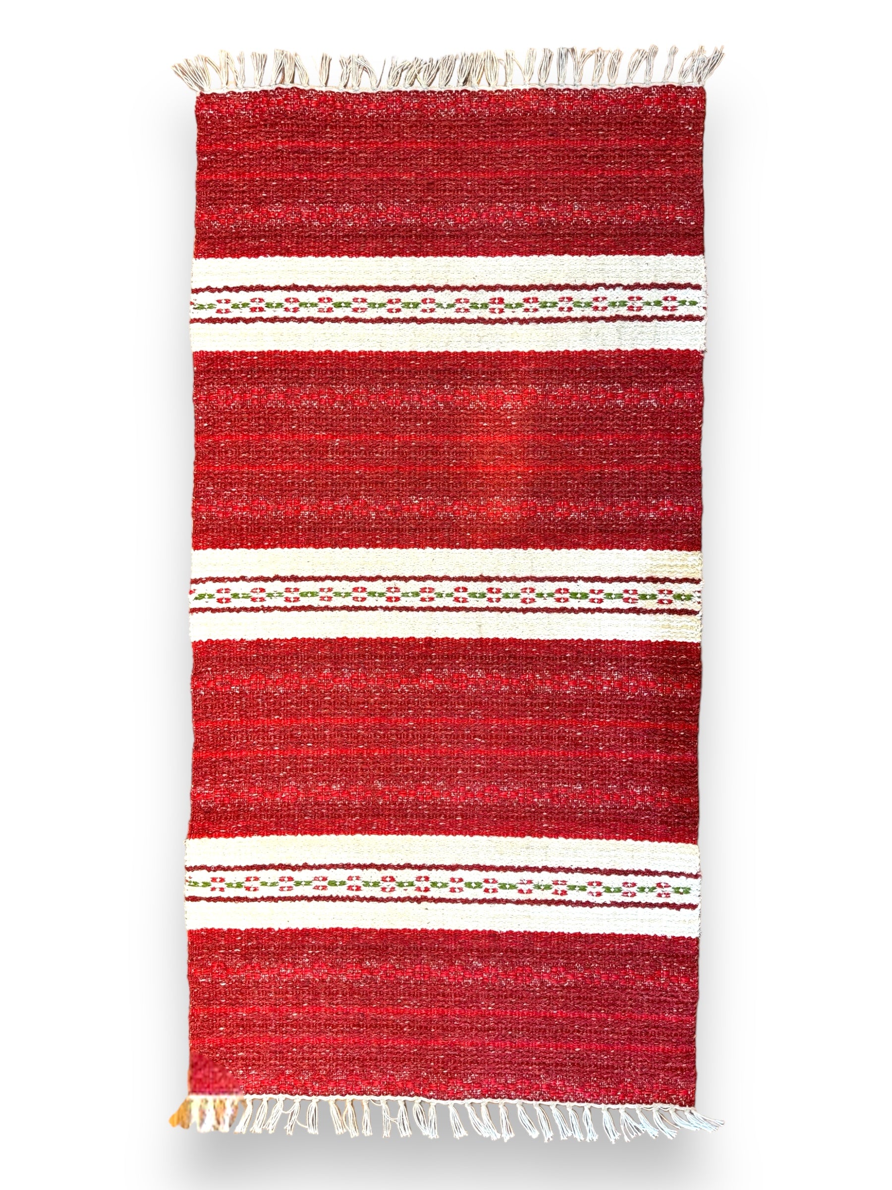 The Rug: Mixed Asta - Red is a durable heavy-duty piece made from cotton and vinyl, featuring white and green striped patterns with fringed edges, perfect for both indoor and outdoor settings.