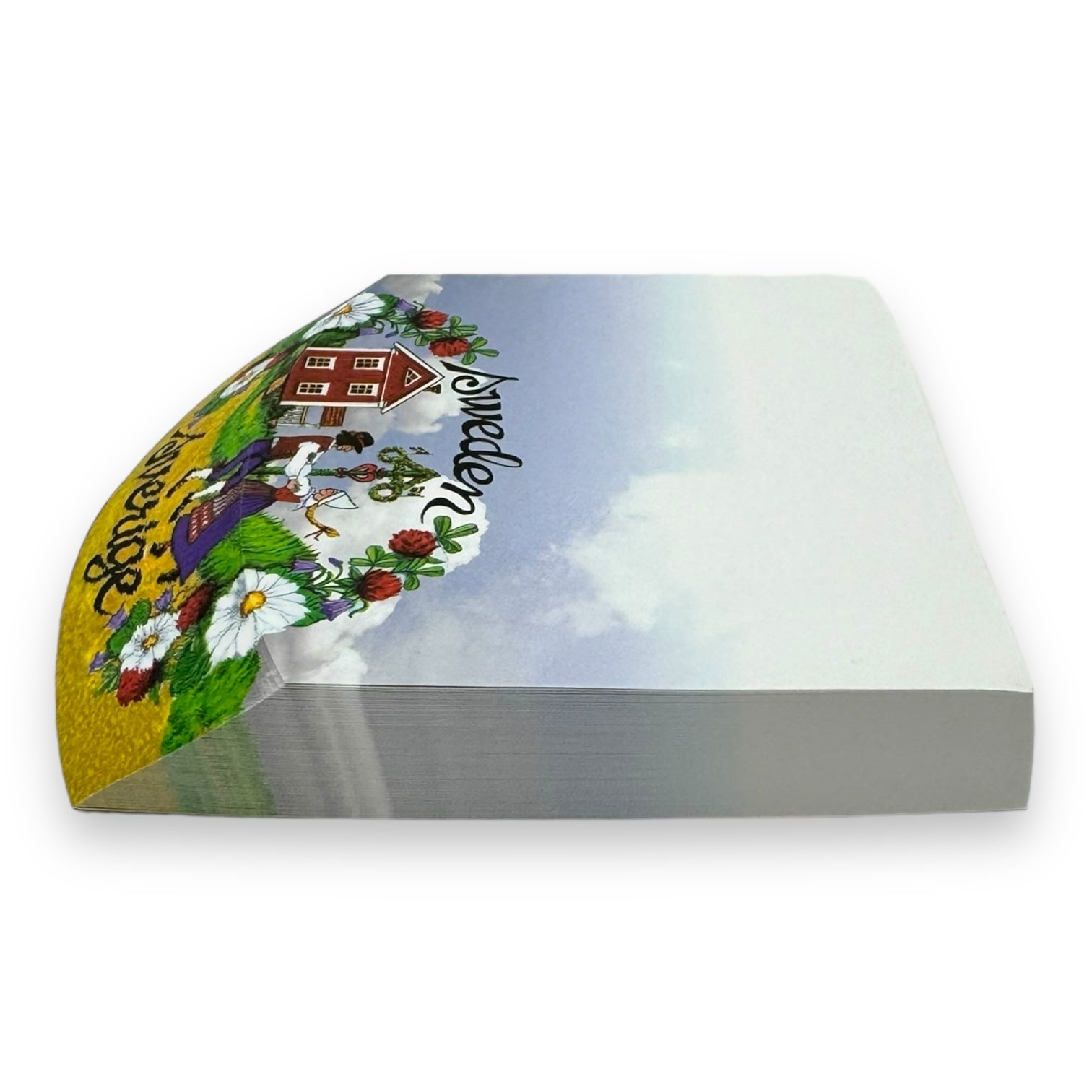 Side view of a large "Tablet: Note Pad Sverige Sweden" showcasing colorful artwork on the top sheet, depicting a farm scene with a red barn, flowers, and the word Avocado in stylized text. The vibrant hues evoke the charm of a summer-meadow.