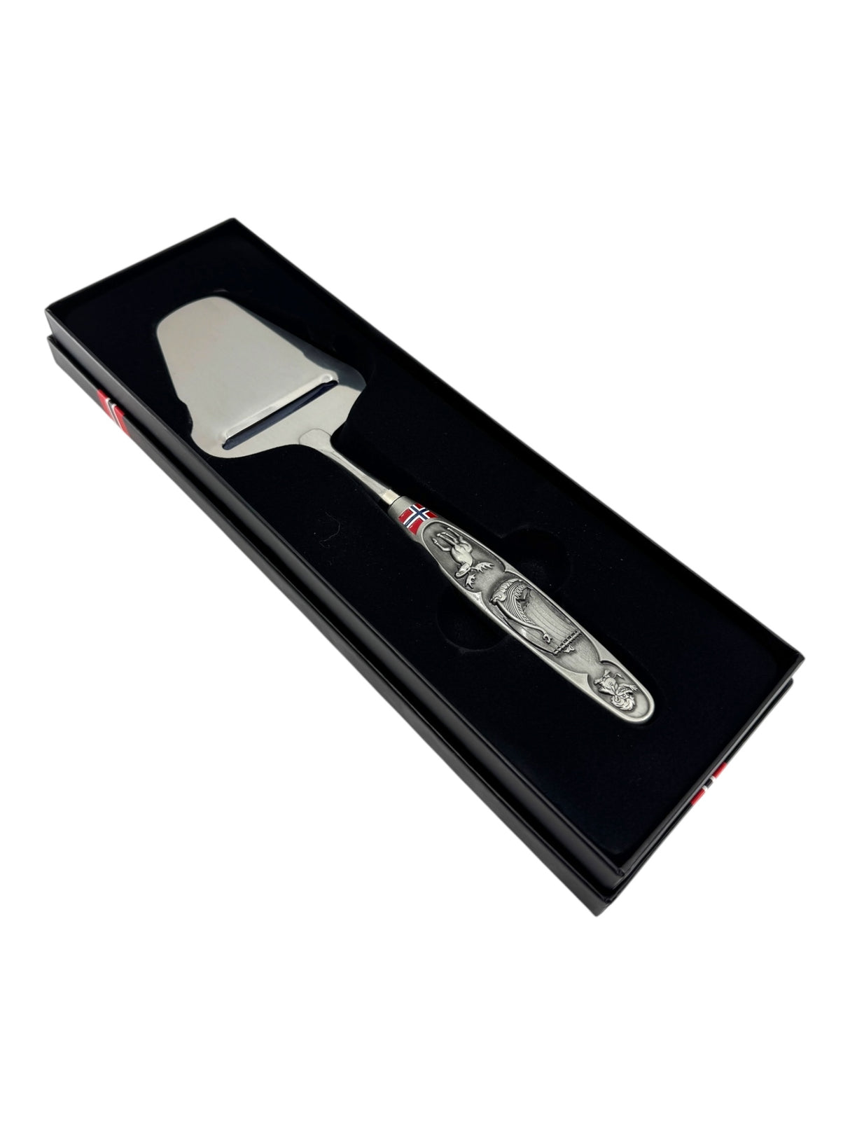 The Smooth Norwegian Cheese Slicer features a pewter handle with Viking ship and moose images, elegantly presented in a black box to highlight its timeless Nordic heritage.