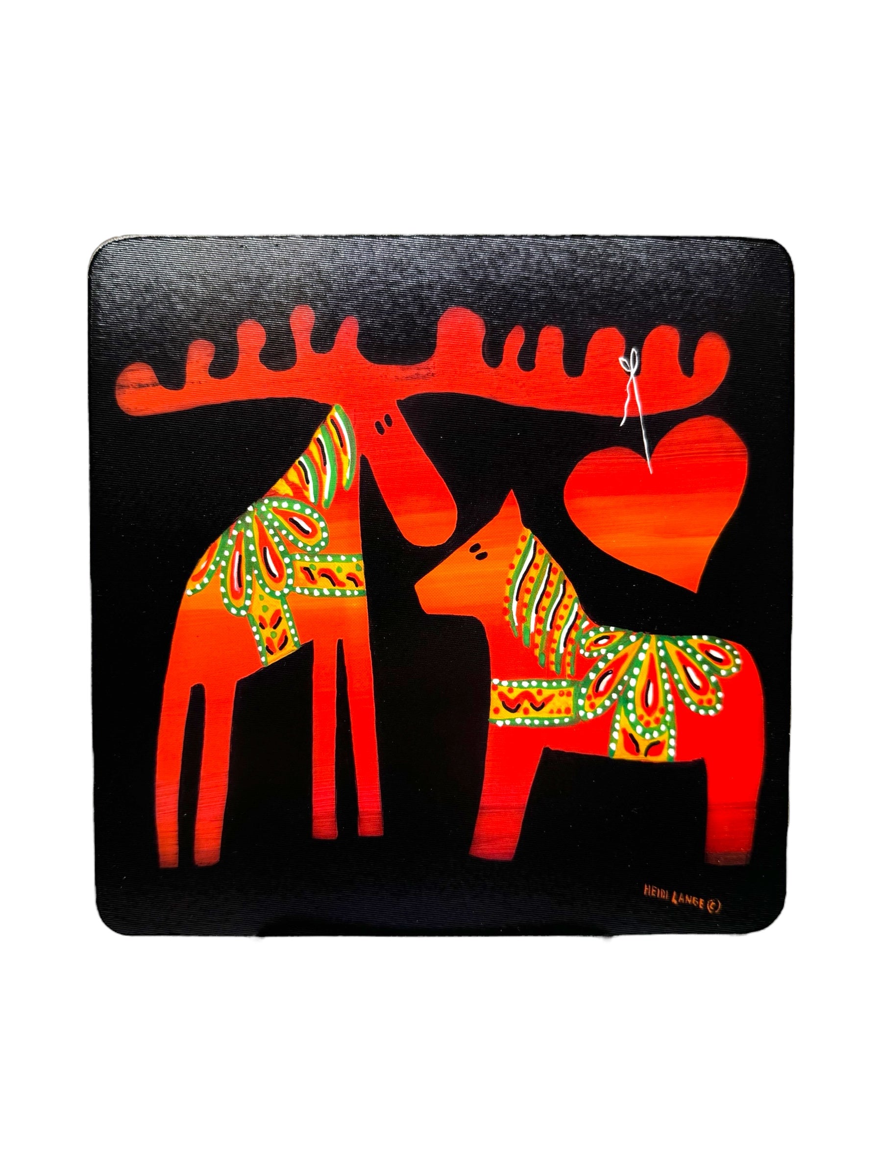 The "Trivet: Moose & Dala by Heidi Lange" features a vibrant depiction of a Dala Moose and Dala Horse, beautifully adorned in colorful patterns and standing beside a red heart on a black background, creating an enchanting design.