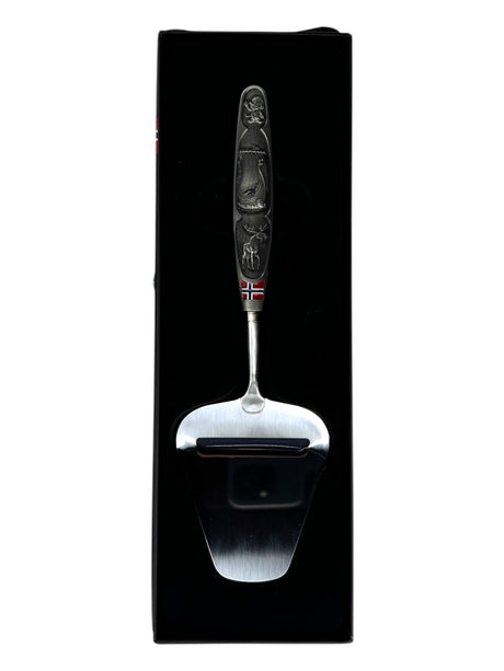 A smooth Norwegian cheese slicer with a pewter handle featuring images of a Viking ship and moose, reflecting Nordic heritage, beautifully presented in a black box.
