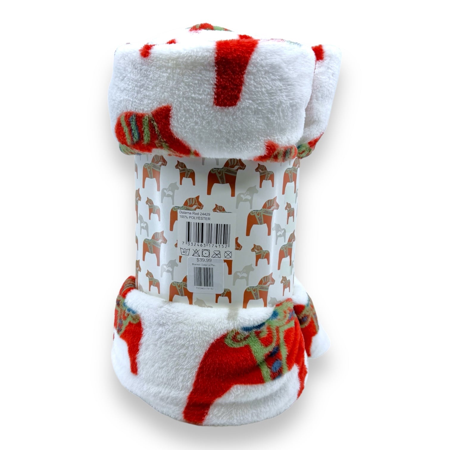 This Dala Horse Throw Blanket, crafted in plush red and white fleece, features a rolled-up design adorned with stylized horse patterns. Wrapped in paper with horse designs and a barcode, it perfectly captures the essence of a classic Swedish blanket.