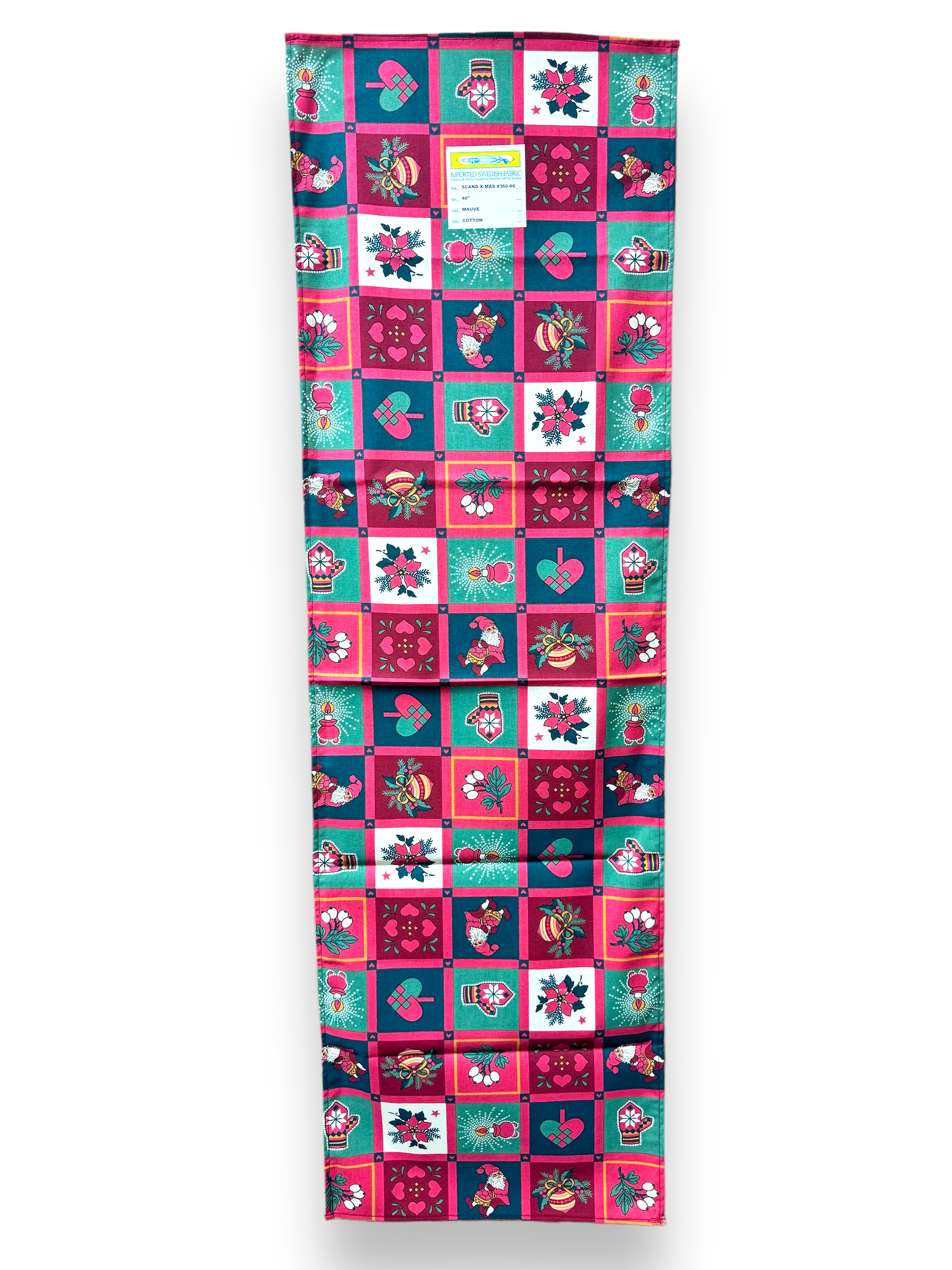 Displayed vertically is the Runner: Scandinavian X-Mas Runner, a vibrant patchwork fabric roll showcasing a grid pattern of floral and heart designs in pink, teal, and navy. Evoking the spirit of a Scandinavian Christmas table runner, it features holiday symbols. A small label is visible at the top.