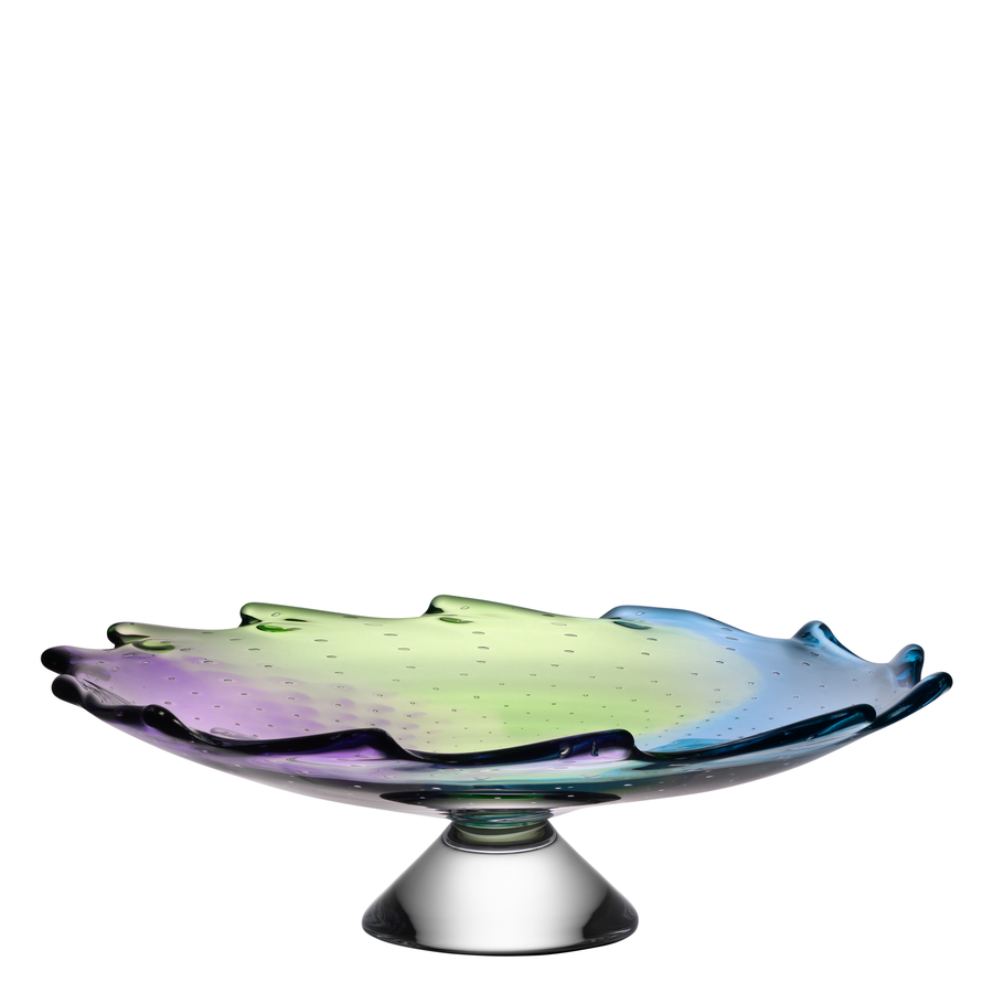 The KostaBoda: Poppy Dish, designed by Kjell Engman, features an exquisite iridescent wavy edge with shades of blue, green, and purple.