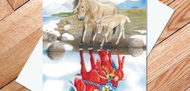 “Norwegian Fjord Reflection” 5x7 greeting card by Rachael Koppendrayer features tan Norwegian Fjord mare and foal with reflections as red Dala horses on grass, set against a wooden floor. Unique art card for any occasion.