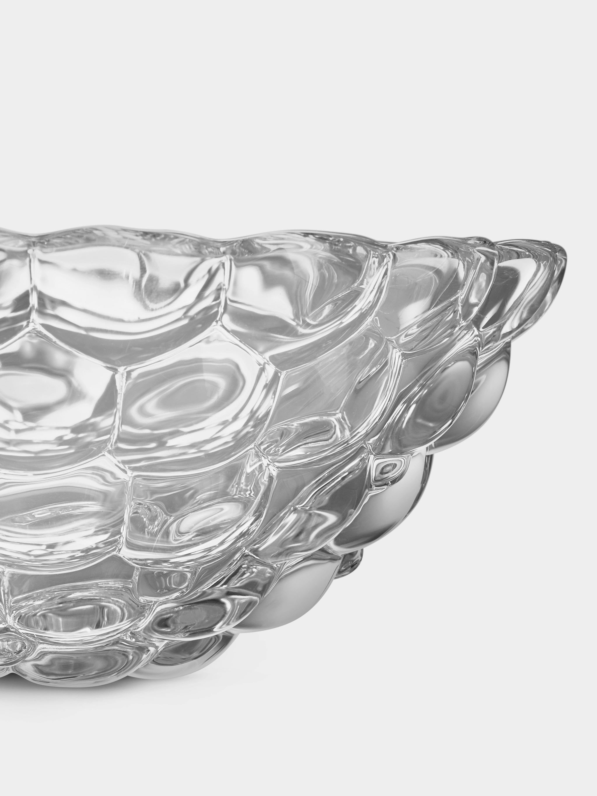 Close-up of the Orrefors Raspberry Bowl Small, showcasing its textured, bubble-like surface pattern that resembles delicate raspberries against a plain background.