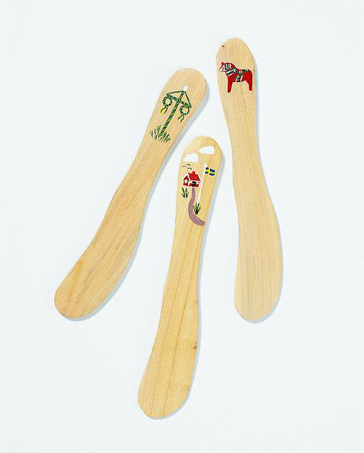 Three Swedish wood butter spreaders feature unique painted designs: a tree, a red house with the Swedish flag, and a traditional hand-painted Dala horse. Made in Sweden, they add charm to your table.