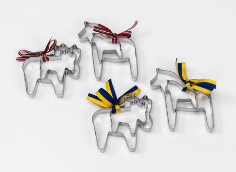 The Swedish Dala Horse Cookie Cutters (2-Pack) set includes four stainless steel animal-shaped cutters with colorful ribbons. Two come with red ribbons, and two are decorated in blue and yellow, all displayed beautifully on a white background.