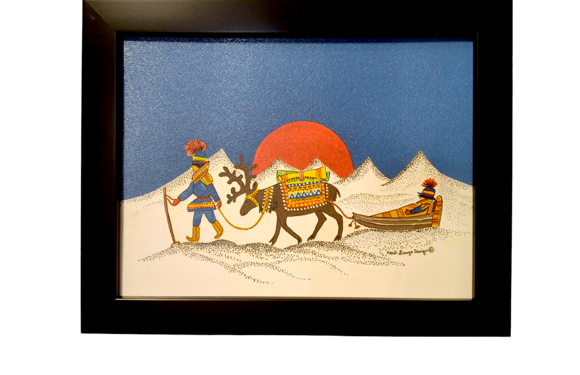 The Artwork: Sami w/ Sled Acrylic Framed Art features a Sami guiding a decorated reindeer across a snowy landscape with the red sun setting behind majestic mountains.