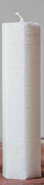 A tall, white Candle Spindle Mesh White 20cm with a hexagonal, textured surface stands elegantly on a wooden surface.